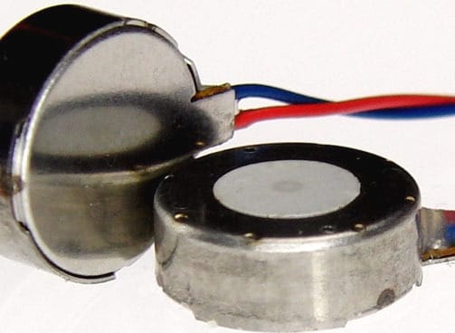 Two C10-100 LRA vibration motors. One is flat on the surface and one is on its side