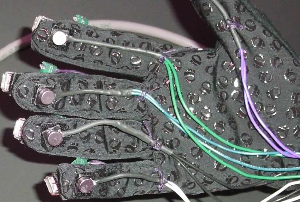 A prototype of a haptic feedback glove with coin vibration motors attached to the tips of the fingers. Wires running from the motors to the wrist 