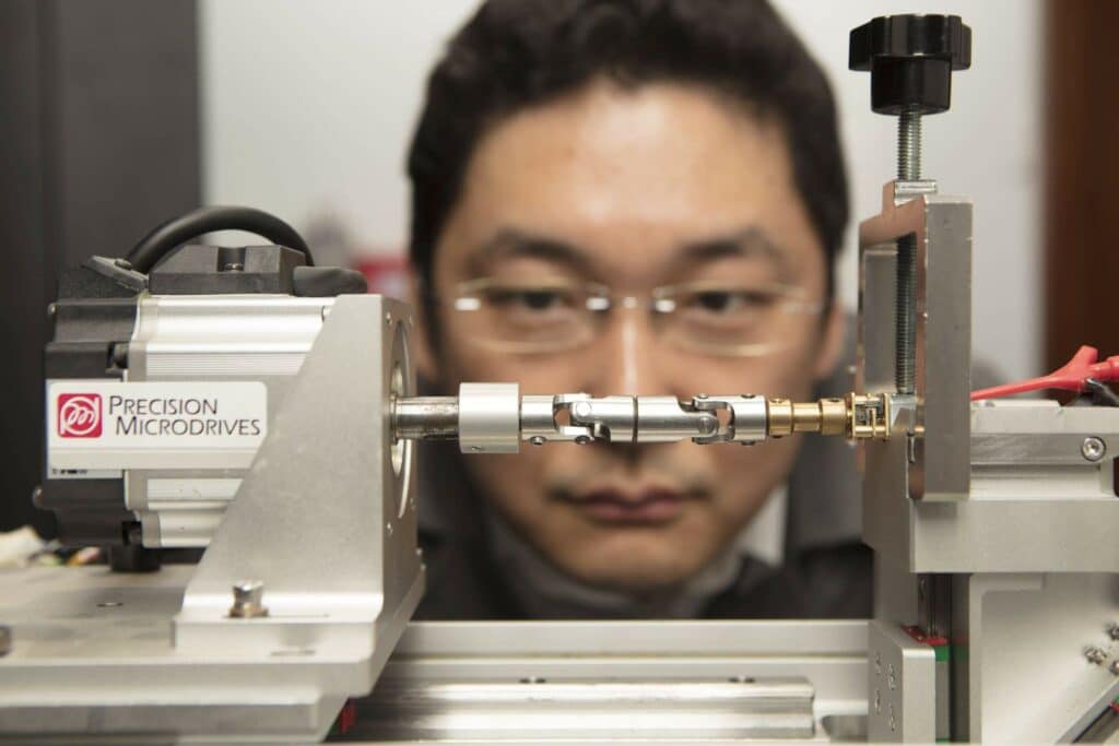 Precision Microdrives engineer examining and testing a motor mechanisms. 