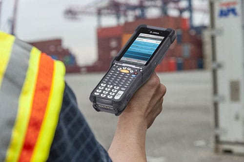 Looking over the right shoulder of a person using a handheld barcode scanner.