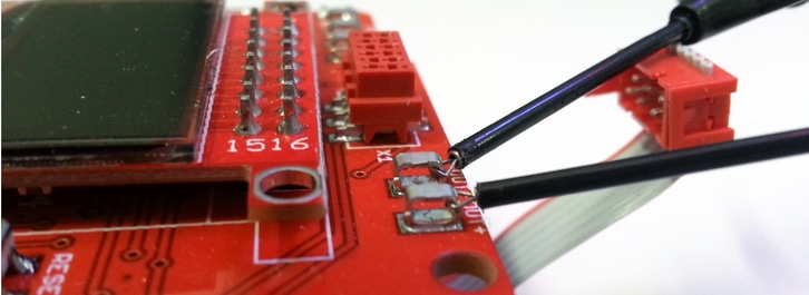 Close up of our haptic feedback kit with the actuator connected to the SMD test points OUT- and OUT+ 