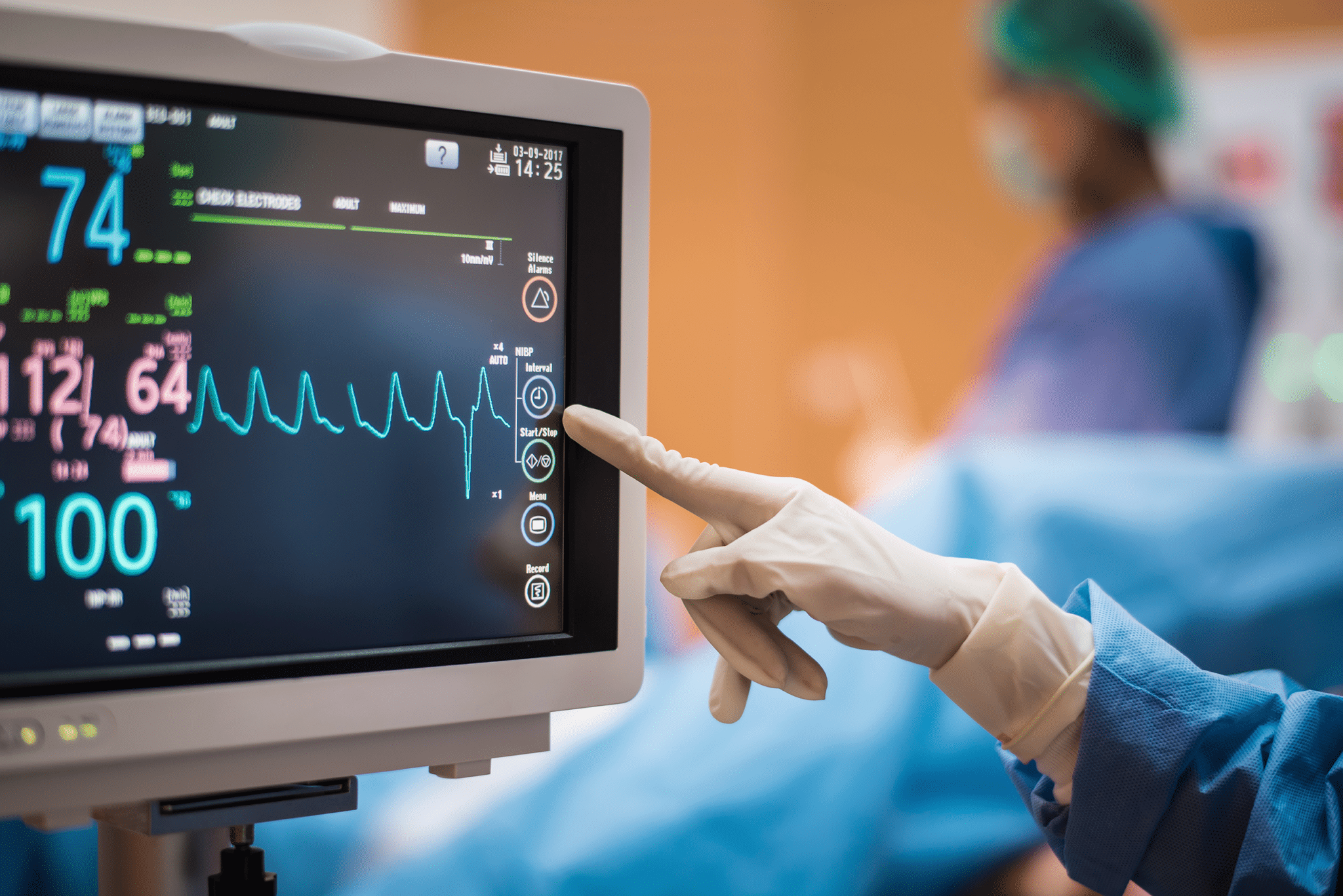 Touchscreen ECG monitor with the hand of a medical professional touching the screen